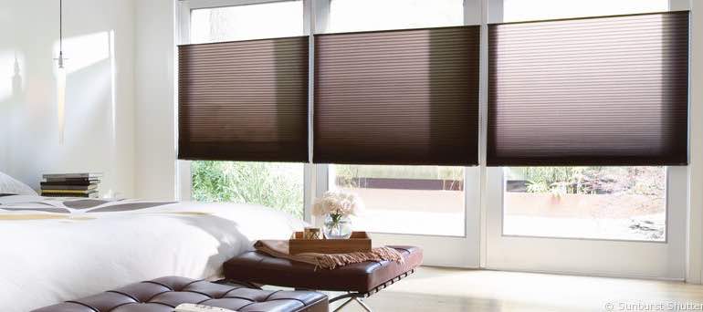 Trendy Minneapolis bedroom with high ceiling windows and brown honeycomb shades.