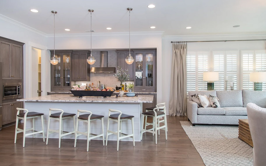 Illuminate your home with custom interior shutters in Minneapolis. White arched shutters in a white kitchen with lots of light.