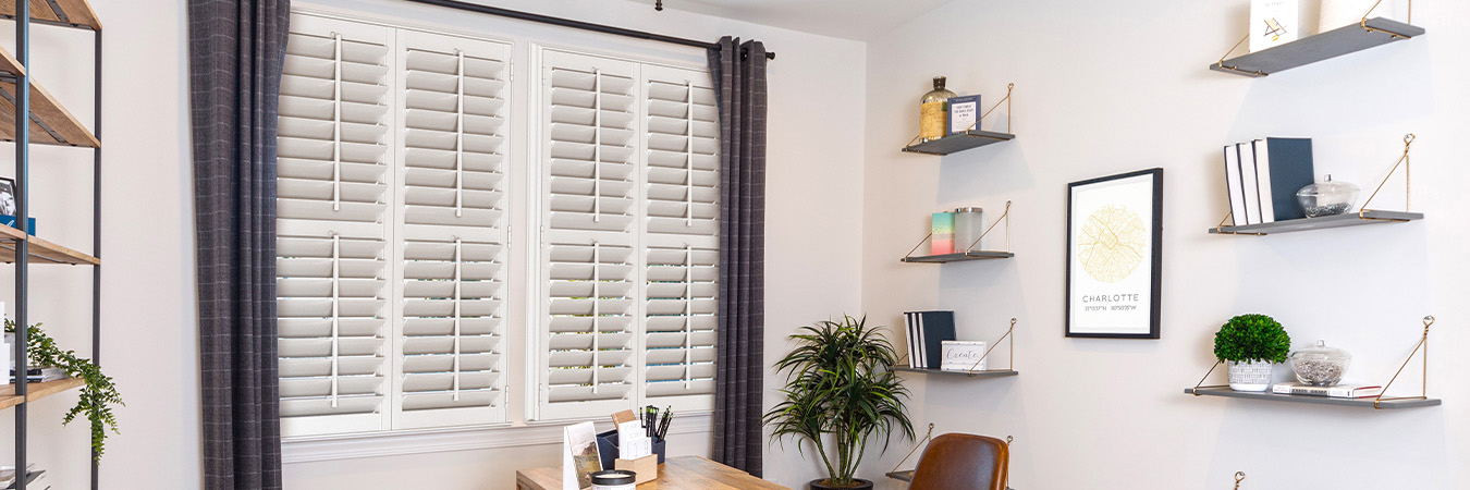 White polywood shutters inside a rustic and modern office setting.