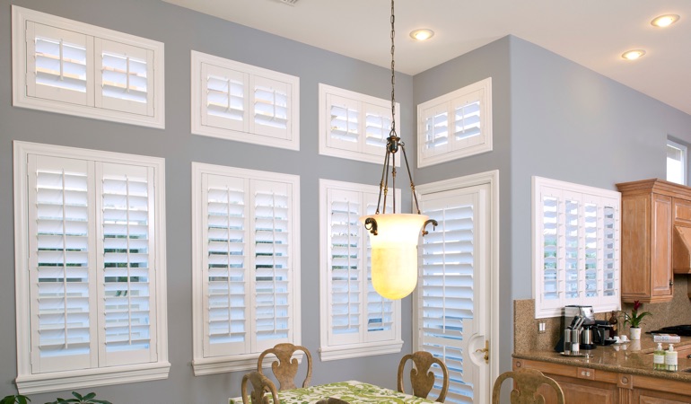 Interior Shutters can resolve both sun glare and heat loss problems. White plantation shutters in kitchen