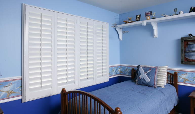 Blue kids bedroom with white plantation shutters in Minneapolis
