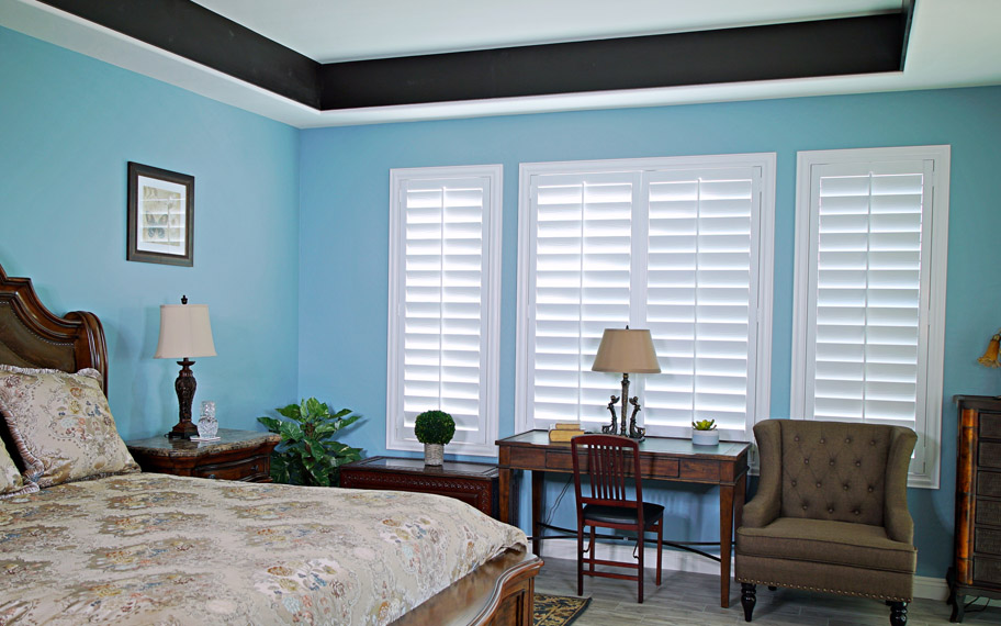 Polywood shutters provide insulation for the perfect temperature all year long in Minneapolis. Polywood shutters in a bedroom.