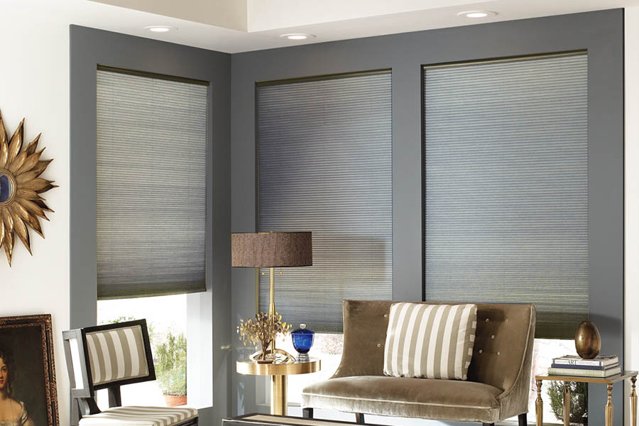 Add style and comfort to your home with cellular shades in Minneapolis. Gray cellular shades in a corner of a stylish living room.