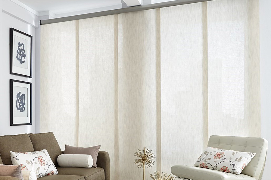 Find window treatments to complete any interior design among our extensive selection at Sunburst Shutters Minneapolis. Long off-white window shades on a tall window in a modern living room