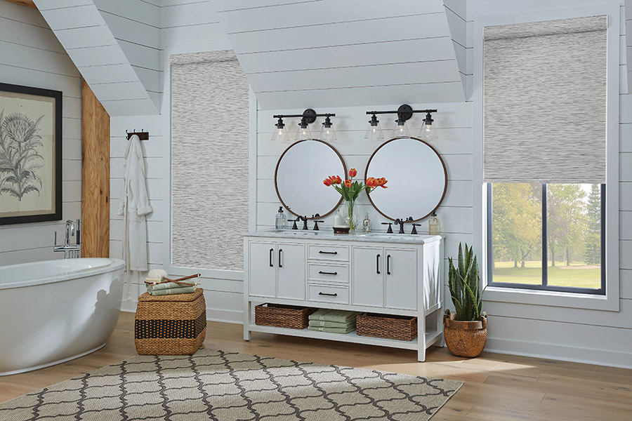 Slim-profile roller shades easily fit shallow windows in your Minneapolis home. Gray patterned roller shades on bathroom windows